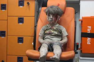Omran, a four-year-old Syrian boy covered in dust and blood, sits in an ambulance after being rescued from the rubble of a building hit by an air strike in the rebel-held Qaterji neighbourhood of the northern Syrian city of Aleppo late on August 17, 2016. / AFP PHOTO / MAHMOUD RSLANMAHMOUD RSLAN/AFP/Getty Images